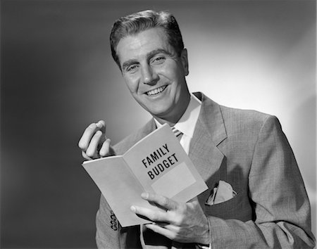 simsearch:846-02797902,k - 1950s MAN IN SUIT HOLDING FAMILY BUDGET BOOKLET Stock Photo - Rights-Managed, Code: 846-02797235