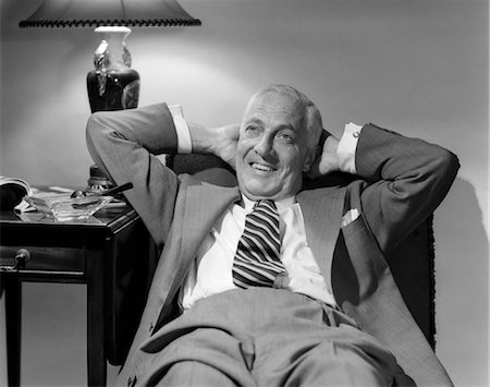 1950s OLDER MAN LOUNGING IN CHAIR WEARING SUIT ARMS BEHIND HEAD Stock Photo - Rights-Managed, Code: 846-02797255