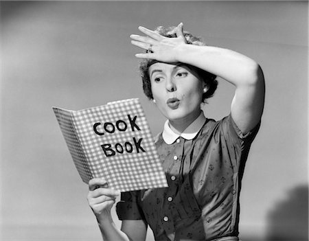 1950s WOMAN HOLDING HAND ON FOREHEAD HOLDING COOKBOOK Foto de stock - Con derechos protegidos, Código: 846-02797313