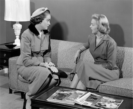 1950s PAIR OF WOMEN SITTING ON LIVING ROOM SOFA TALKING ONE WEARING SUIT WITH HAT & GLOVES Stock Photo - Rights-Managed, Code: 846-02797414