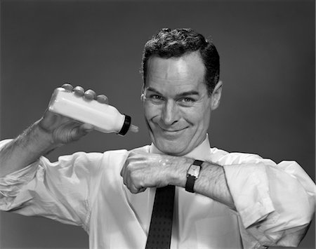1950s MAN HOLDING BOTTLE OF MILK CHECKING TEMPERATURE ON HAND Stock Photo - Rights-Managed, Code: 846-02797538