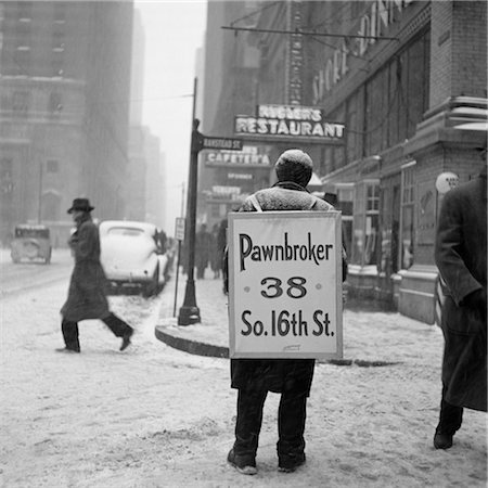 simsearch:846-02795969,k - 1930s WINTER STREET SCENE OF MAN WEARING PAWNBROKER SANDWICH BOARD Stock Photo - Rights-Managed, Code: 846-02797619