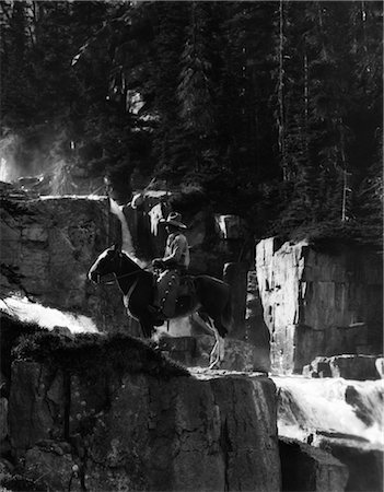 1920s 1930s COWBOY ON HORSE BY WATERFALL IN PINE FOREST GIANTS STEPS PARADISE VALLEY CANADA WESTERN FRONTIER Stock Photo - Rights-Managed, Code: 846-02797780