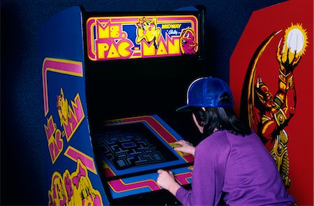 1980s TEEN GIRL WEAR BASEBALL CAP PLAYING MS PAC MAN VIDEO GAME IN ARCADE Stock Photo - Rights-Managed, Code: 846-02791675