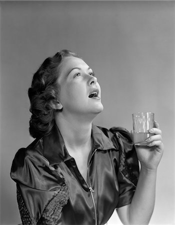 1940s 1950s BRUNETTE WOMAN HOLD GLASS GARGLE GARGLING MOUTH OPEN HEAD BACK SORE THROAT BAD BREATH MOUTHWASH MEDICINE Stock Photo - Rights-Managed, Code: 846-02791682