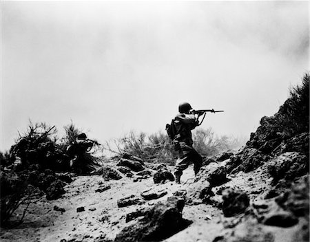 1940s US ARMY INFANTRY MEN SHOOTING RIFLES IN ACTION CARRYING HEAVY BACKPACKS DURING WW2 COMBAT Stock Photo - Rights-Managed, Code: 846-02791732