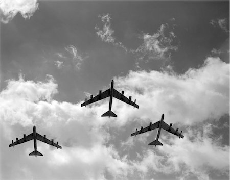 1950s THREE B.52 BOMBERS IN FLIGHT FORMATION AS SEEN FROM THE GROUND DIRECTLY OVER HEAD CLOUDS SILHOUETTES SKY Stock Photo - Rights-Managed, Code: 846-02791794