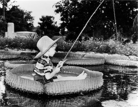 retro fishing - YOUNG BOY FLOATING ON LILLY PAD FISHING IN POND Foto de stock - Con derechos protegidos, Código: 846-02791809