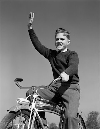 1940s 1950s SMILING BOY RIDING BIKE WAVING ARM IN AIR Stock Photo - Rights-Managed, Code: 846-02792048