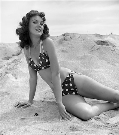 1950s BRUNETTE BATHING BEAUTY STRETCHED OUT IN SAND WEARING POLKA-DOT BIKINI Stock Photo - Rights-Managed, Code: 846-02792135
