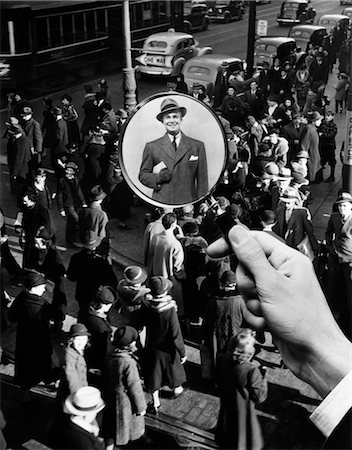 1930s 1940s PEDESTRIAN STREET CROWD MAGNIFYING GLASS FOCUSED ON SINGLE WELL DRESSED MAN A FACE IN THE CROWD Stock Photo - Rights-Managed, Code: 846-02792246