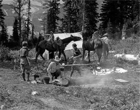 1930s GROUP MEN WOMEN AT CAMPSITE COOKING FIRE HORSES CAMPFIRE WILDERNESS ADVENTURE COWBOY TENT CANADA ASSINIBOINE Stock Photo - Rights-Managed, Code: 846-02792251