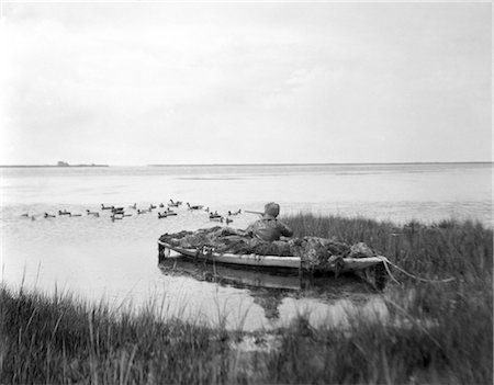 ANNÉES 1930 ANNÉES 1920 HOMME CAMOUFLÉ DUCK BOAT SHOOTING BARNEGAT BAY NEW JERSEY Photographie de stock - Rights-Managed, Code: 846-02792366