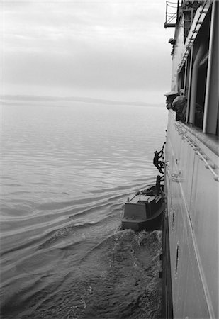 1950s MAN CLIMBING ABOARD SHIP FROM SMALL MOTOR LAUNCH UP A ROPE LADDER Stock Photo - Rights-Managed, Code: 846-02792472