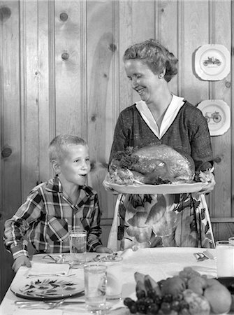 simsearch:846-02793176,k - 1950s WOMAN IN APRON PUTTING TURKEY ON TABLE WITH SON LOOKING ON EAGERLY Foto de stock - Con derechos protegidos, Código: 846-02792861