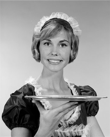 right - 1960s GIRL IN WAITRESS UNIFORM WITH MATCHING LACE HEADPIECE SMILING WHILE HOLDING UP AN EMPTY SERVING TRAY Stock Photo - Rights-Managed, Code: 846-02793080