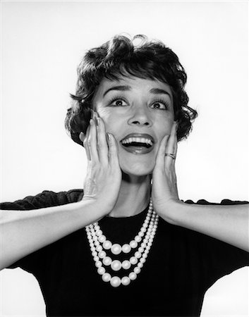 strand - 1950s 1960s WOMAN 3 STRAND NECKLACE HAND UP TO CHEEKS HAPPY SMILING ELATED JOY WIN SURPRISE FUNNY FACE EXPRESSION CHARACTER Stock Photo - Rights-Managed, Code: 846-02793082