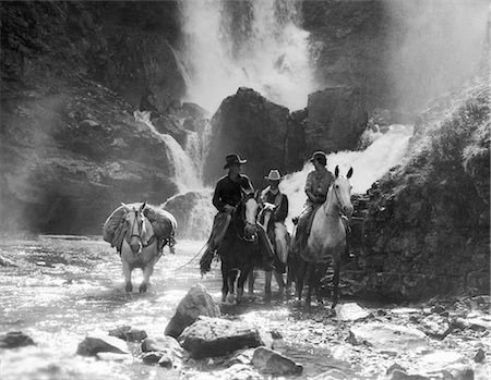 simsearch:846-02793153,k - 1930s TWO MEN AND WOMAN RIDING HORSEBACK WITH FOURTH HORSE CARRYING SUPPLIES IN STREAM Stock Photo - Rights-Managed, Code: 846-02793235
