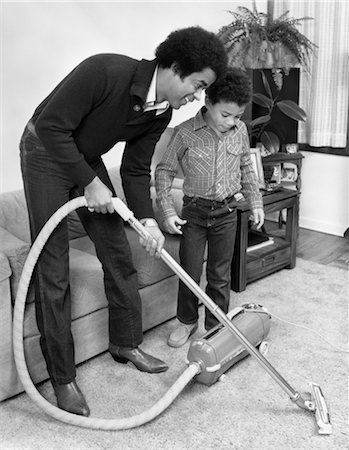 1970s 1980s AFRICAN AMERICAN MAN FATHER AND SON BOY VACUUMING CARPET VACUUM Stock Photo - Rights-Managed, Code: 846-02793310