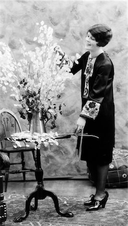 1920s WOMAN MAKING FLOWER ARRANGEMENT STANDING BY CHIPPENDALE TABLE ON ORIENTAL CARPET Stock Photo - Rights-Managed, Code: 846-02793359