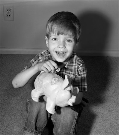 1950s SMILING BOY PUTTING COIN INTO PIGGY BANK Stock Photo - Rights-Managed, Code: 846-02793493