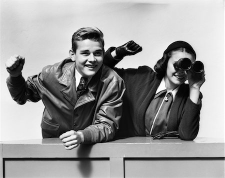 simsearch:846-02793798,k - 1940s TEENAGE COUPLE BOY GIRL WATCHING RACE WITH BINOCULARS EXCITED CHEERING Stock Photo - Rights-Managed, Code: 846-02793540