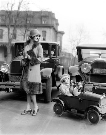 1930s GIRL LOOKING INTO COMPACT SITTING IN HER TOY CAR WITH HER WIRE TERRIER MOTHER LOOKING WATCHING Stock Photo - Rights-Managed, Code: 846-02793566