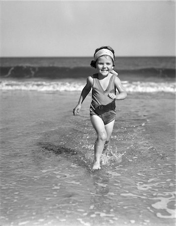 1930s SMILING LITTLE GIRL RUNNING OUT OF SURF AT BEACH Stock Photo - Rights-Managed, Code: 846-02793684