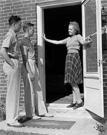 simsearch:846-02793798,k - 1930s 1940s TEEN GIRL SMILING WELCOMING TWO BOYS AT FRONT DOOR Stock Photo - Rights-Managed, Code: 846-02793695