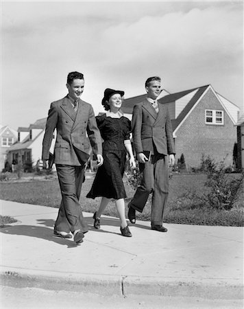 simsearch:846-02793798,k - 1930s 1940s TWO TEEN BOYS ONE GIRL DRESSED UP WALKING DOWN SUBURBAN SIDEWALK Stock Photo - Rights-Managed, Code: 846-02793690