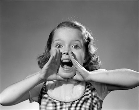 1950s LITTLE GIRL SHOUTING YELLING HANDS CUPPED AROUND WIDE OPEN MOUTH Stock Photo - Rights-Managed, Code: 846-02793718