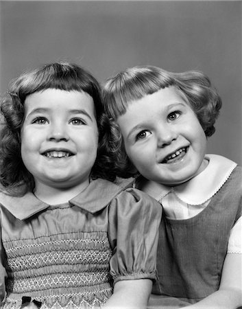 1950s 2 GIRLS WITH BANGS & PETER PAN COLLARS DRESS & CORDUROY JUMPER SMILING PORTRAITS PRESCHOOL INNOCENCE CUTE PLAYFUL Stock Photo - Rights-Managed, Code: 846-02793712