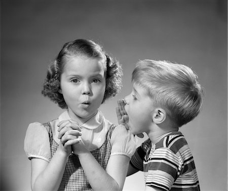 1950s BOY WHISPERING IN GIRLS EAR SECRET RUMOR GOSSIP Stock Photo - Rights-Managed, Code: 846-02793729