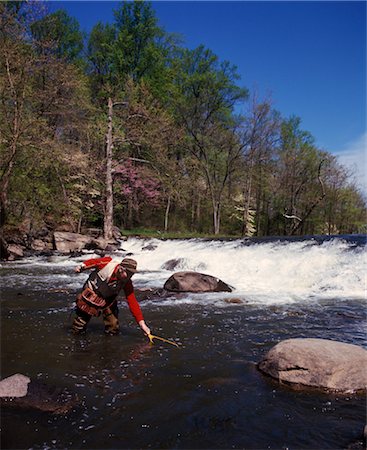 fishing 1970s - 1970s MAN STANDING IN STREAM FLY FISHING SPRING SEASON WATER ROD REEL RED SHIRT WATERFALL ROCKS Stock Photo - Rights-Managed, Code: 846-02793873