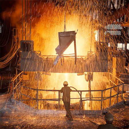 1960s MAN STANDING AMID SPARKS OF MOLTEN METAL INSIDE A STEEL MILL Stock Photo - Rights-Managed, Code: 846-03164751