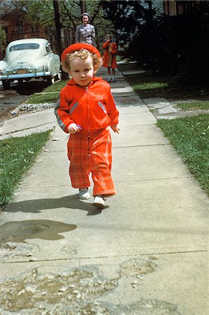 1950s LITTLE BOY IN RED OUTFIT RUNNING ON PAVEMENT WITH MOTHER JUST BEHIND Stock Photo - Rights-Managed, Code: 846-03164804