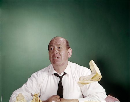 simsearch:846-02795767,k - 1960s TIRED OVERWORKED BUSINESSMAN AT DESK SHIRTSLEEVES LOOSE TIE PAPER FLOATING FUNNY EXPRESSION Stock Photo - Rights-Managed, Code: 846-03165142
