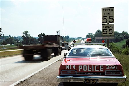 1970s POLICE CAR WITH RADAR GUN CHECKING FOR SPEEDERS IN 55 MPH SPEED ZONE Stock Photo - Rights-Managed, Code: 846-03165169