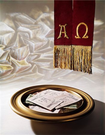 BRASS OFFERING PLATE FILLED WITH TITHING ENVELOPES AND RED CLOTH EMBROIDERED WITH SIGNS FOR ALPHA AND OMEGA Stock Photo - Rights-Managed, Code: 846-03165296