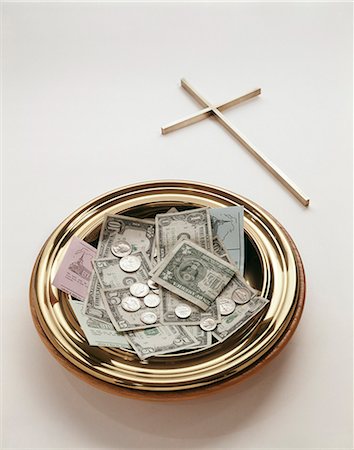 BRASS OFFERING PLATE FILLED WITH MONEY COINS BILLS TITHING ENVELOPES AND A CROSS Stock Photo - Rights-Managed, Code: 846-03165584