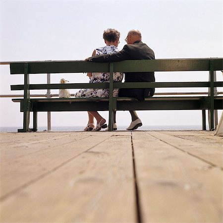 elderly lady back - 1970s BACK VIEW OF SENIOR COUPLE SITTING ON BOARDWALK BENCH OVERLOOKING OCEAN BEACH Stock Photo - Rights-Managed, Code: 846-03165793