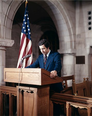 speech - 1970s MAN IN CHURCH ON PULPIT GIVING A SPEECH WITH AN AMERICAN FLAG BACKGROUND Stock Photo - Rights-Managed, Code: 846-03165818