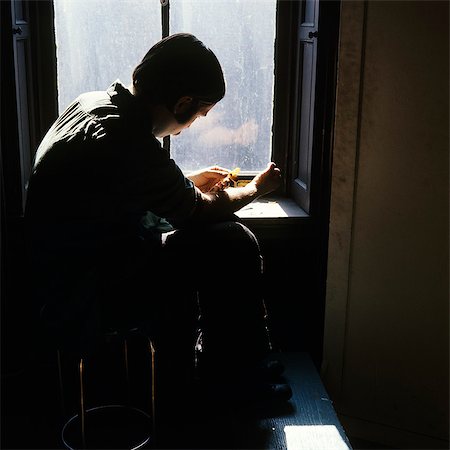 1980s MAN DRUG ADDICT SITTING BY WINDOW STICKING NEEDLE IN ARM Stock Photo - Rights-Managed, Code: 846-03166050