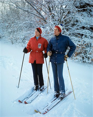 1970s FULL LENGTH COUPLE STANDING ON SKIS WOMAN RED JACKET MAN BLUE CLOTHES Stock Photo - Rights-Managed, Code: 846-03166183