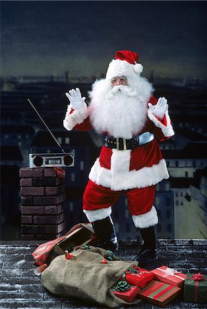 simsearch:846-05647602,k - SANTA CLAUS DANCING ON A ROOFTOP TO RADIO TUNES AT NIGHT WITH CITY IN BACKGROUND Stock Photo - Rights-Managed, Code: 846-03166202