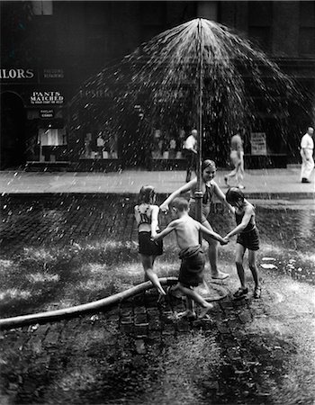1930s INNER CITY CHILDREN PLAYING IN SPRAY FROM FIRE HYDRANT WATER SPRINKLER Stock Photo - Rights-Managed, Code: 846-03163407