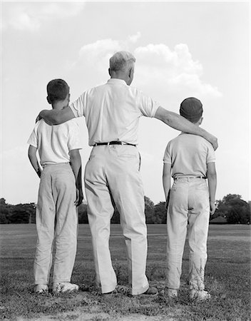 father and son vintage - 1960s TWO SONS BOYS MAN LOOKING OUT FROM BEHIND Stock Photo - Rights-Managed, Code: 846-03163400