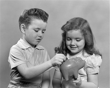1950s CHILD PUTTING MONEY INTO PIGGY BANK CHILDREN Stock Photo - Rights-Managed, Code: 846-03163455