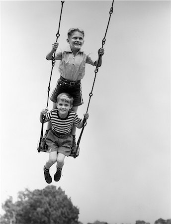 playground retro - 1930s TWO SMILING BOYS SITTING STANDING ON PLAYGROUND SWING Stock Photo - Rights-Managed, Code: 846-03163534