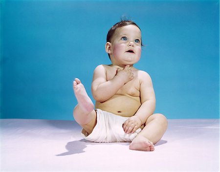 1960s BABY WEARING DIAPER SITTING LOOKING UP AND KICKING ONE LEG UP Stock Photo - Rights-Managed, Code: 846-03163903